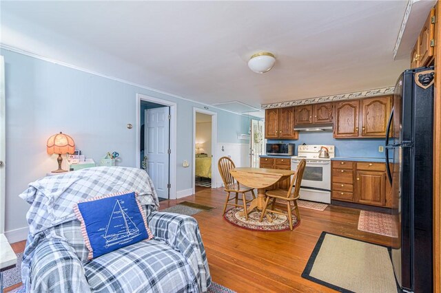 223 Mautucket Rd, South Kingstown, RI 02879 - kitchen with electric stove, freestanding refrigerator, stainless steel microwave, dark wood finished floors, and under cabinet range hood