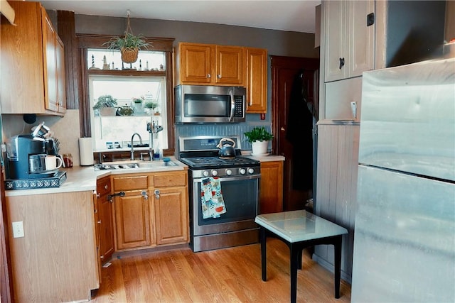 23 Majestic Ave, Warwick, RI 02888 - kitchen featuring stainless steel appliances, light countertops, light wood finished floors, decorative backsplash, and brown cabinets