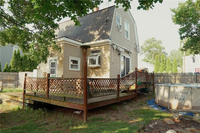 23 Majestic Ave, Warwick, RI 02888 - rear view of house with a wooden deck, a gambrel roof, cooling unit, and a shingled roof
