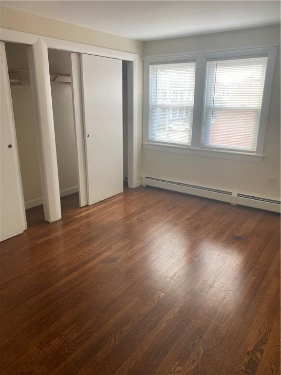 26 Anchor St, Providence, RI 02908 - unfurnished bedroom featuring a baseboard radiator, dark wood finished floors, and multiple closets