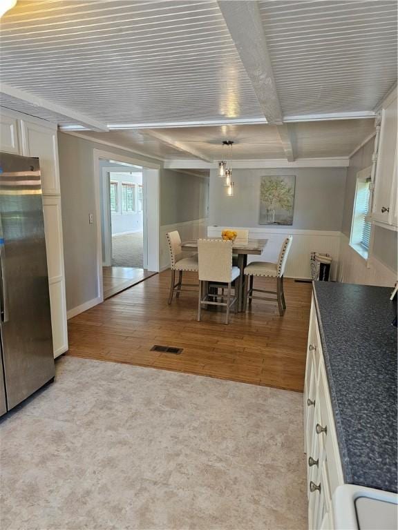 41 Park Ln, Coventry, RI 02816 - dining room with light wood-type flooring, beam ceiling, and a wainscoted wall