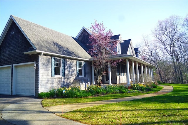 56 Ocean Ridge Dr, Charlestown, RI 02813 - view of front of house with a porch, a front yard, a garage, and roof with shingles