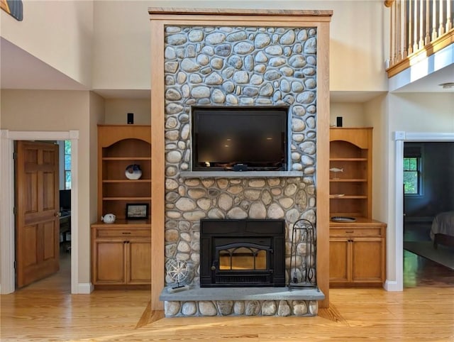 56 Ocean Ridge Dr, Charlestown, RI 02813 - living area featuring wood finished floors, built in shelves, a towering ceiling, and a fireplace
