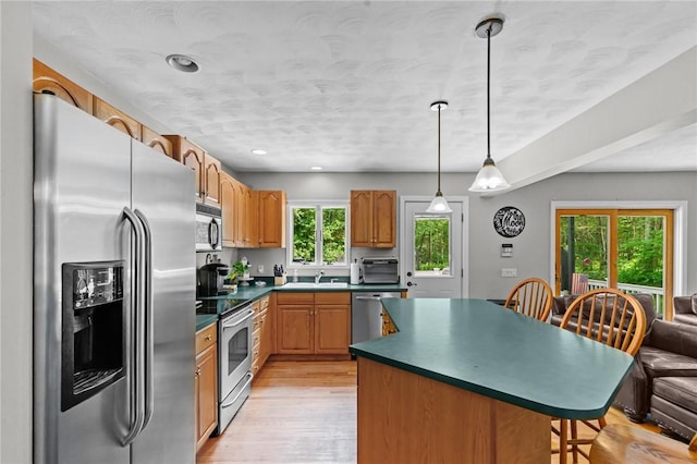 8 Anthony Rd, Foster, RI 02825 - kitchen with stainless steel appliances, dark countertops, a kitchen island, light wood-style floors, and a kitchen bar