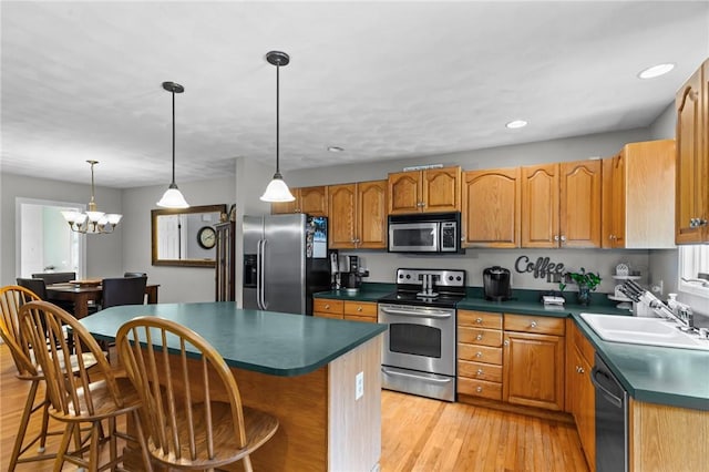 8 Anthony Rd, Foster, RI 02825 - kitchen with stainless steel appliances, dark countertops, light wood-style flooring, a center island, and a breakfast bar area