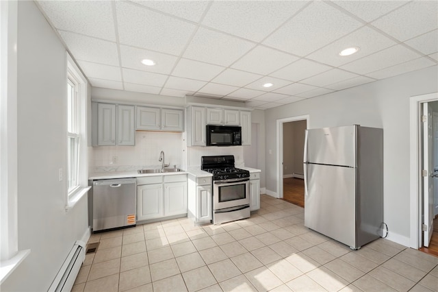 65 Lancaster St Unit 1, Providence, RI 02906 - kitchen with appliances with stainless steel finishes, light countertops, a baseboard heating unit, a drop ceiling, and light tile patterned floors