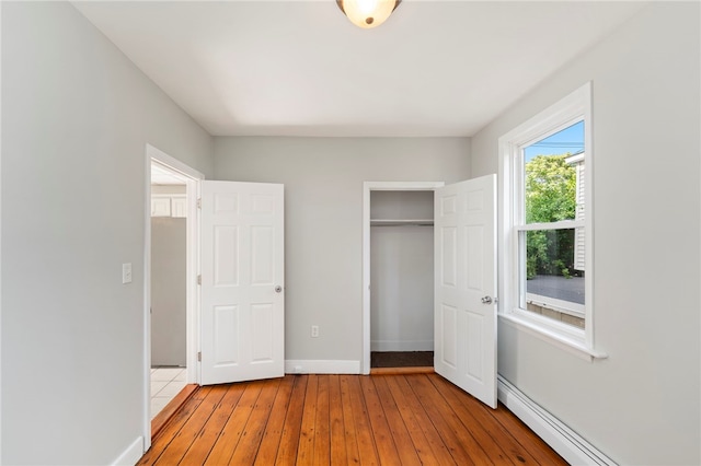 65 Lancaster St Unit 1, Providence, RI 02906 - unfurnished bedroom featuring a closet, light wood-type flooring, and a baseboard heating unit