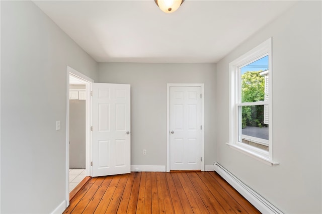 65 Lancaster St Unit 1, Providence, RI 02906 - unfurnished bedroom with a baseboard heating unit and light wood finished floors