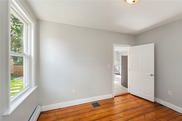 65 Lancaster St Unit 1, Providence, RI 02906 - spare room with plenty of natural light, a baseboard heating unit, and light wood-style flooring