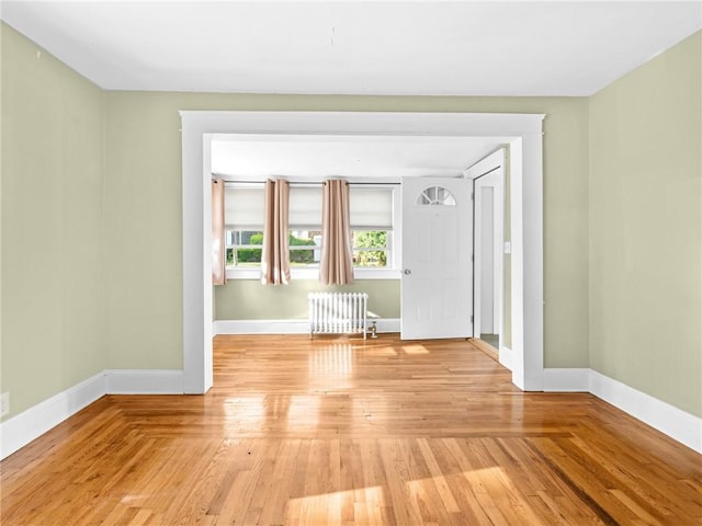124 Everleth Ave, Warwick, RI 02888 - empty room with radiator heating unit and light wood finished floors