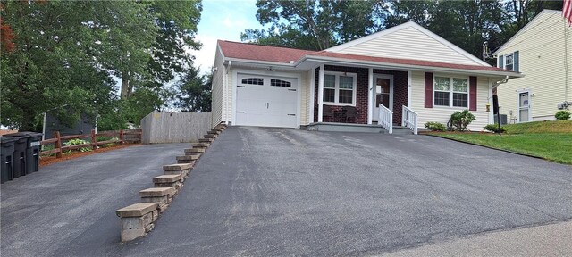 26 Morton Ave, Johnston, RI 02919 - view of front of house with driveway, an attached garage, and covered porch