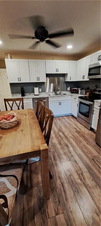 26 Morton Ave, Johnston, RI 02919 - kitchen featuring appliances with stainless steel finishes, white cabinetry, light wood-style flooring, light countertops, and ceiling fan