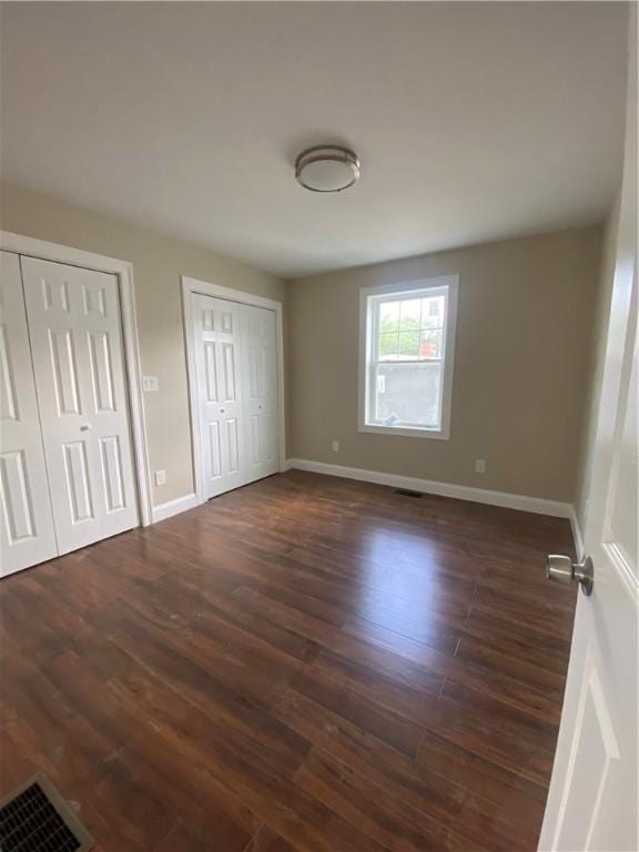 4 Halton St, Providence, RI 02907 - unfurnished bedroom featuring two closets and dark wood-style flooring