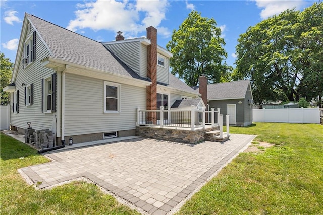 58 E St, West Warwick, RI 02893 - back of house featuring a patio, a shingled roof, a deck, and a chimney