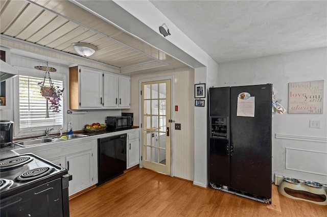 36 Dundas Ave, Warwick, RI 02889 - kitchen with black appliances, light wood finished floors, and white cabinetry