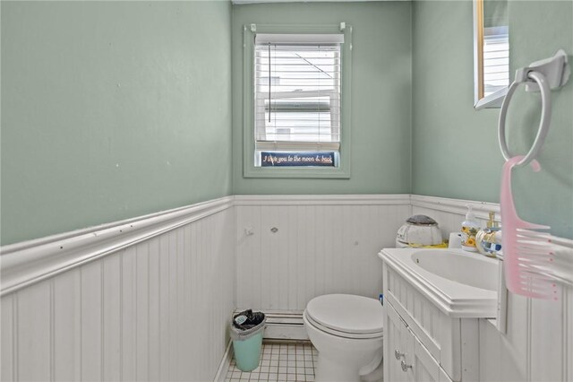 36 Dundas Ave, Warwick, RI 02889 - half bath featuring vanity, baseboard heating, a wainscoted wall, and tile patterned floors