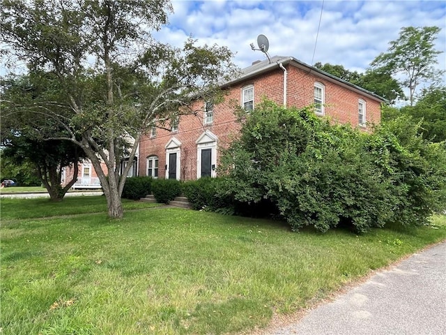 502 Providence St, West Warwick, RI 02893 - view of front facade with brick siding and a front yard