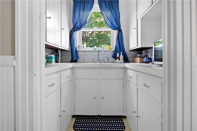 11 Branch Ave, Cranston, RI 02910 - kitchen featuring white cabinetry, light countertops, tasteful backsplash, and stainless steel microwave