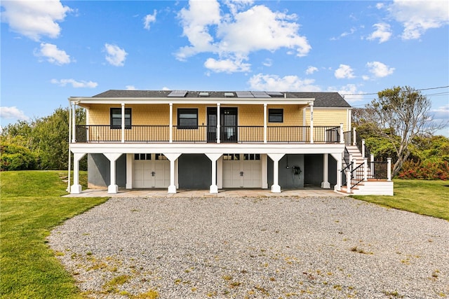 212 Round Pond Rd, Little Compton, RI 02837 - rear view of house with a garage, a lawn, stairway, and gravel driveway