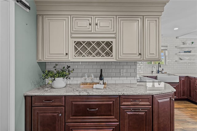 212 Round Pond Rd, Little Compton, RI 02837 - kitchen with backsplash, wood finished floors, light stone countertops, dark brown cabinets, and crown molding