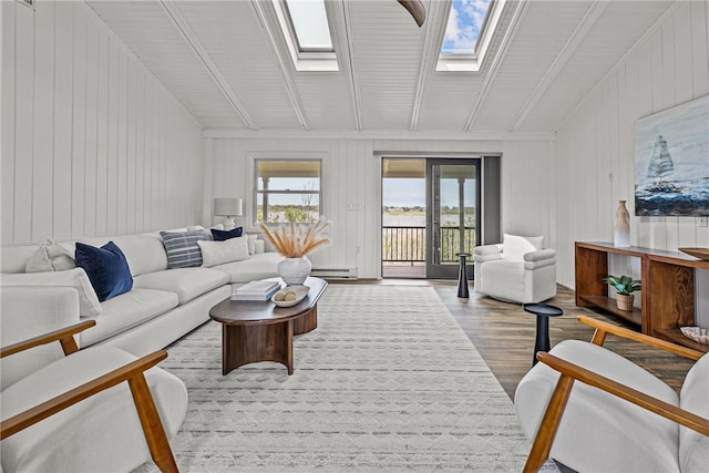 212 Round Pond Rd, Little Compton, RI 02837 - living room featuring wood finished floors, lofted ceiling, baseboard heating, wooden walls, and a skylight