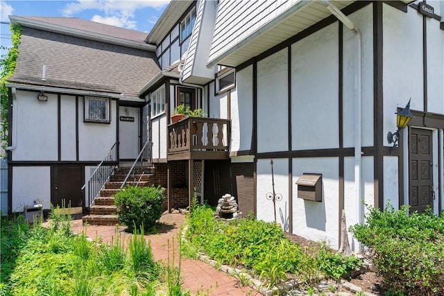 129 Academy Ave, Providence, RI 02908 - rear view of house with stucco siding, a wooden deck, stairs, and roof with shingles