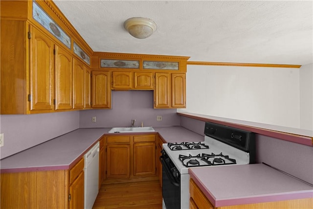 129 Academy Ave, Providence, RI 02908 - kitchen with white appliances, brown cabinetry, light wood finished floors, a textured ceiling, and light countertops
