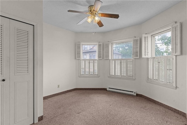 129 Academy Ave, Providence, RI 02908 - unfurnished bedroom with baseboard heating, carpet floors, multiple windows, a textured ceiling, and a closet