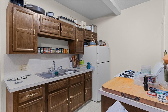 129 Academy Ave, Providence, RI 02908 - kitchen with light countertops, freestanding refrigerator, dark brown cabinets, and light floors