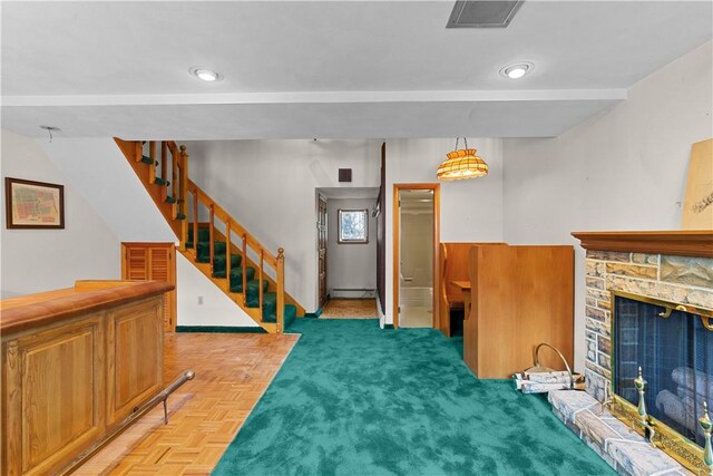 129 Academy Ave, Providence, RI 02908 - living area featuring a baseboard heating unit, a stone fireplace, and stairway