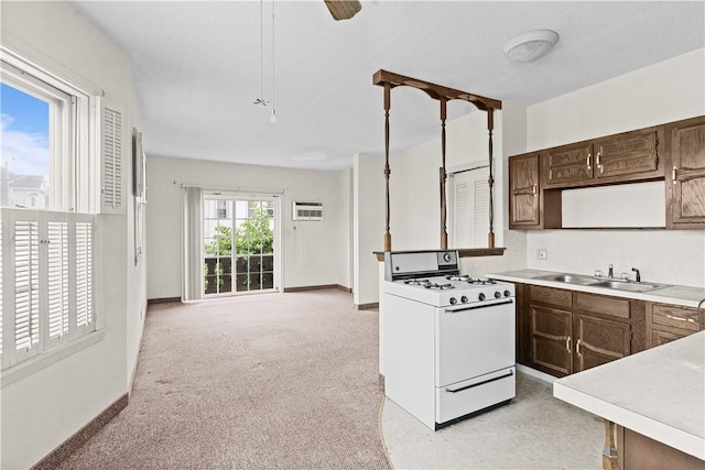 129 Academy Ave, Providence, RI 02908 - kitchen with gas range gas stove, light countertops, light carpet, and dark brown cabinetry
