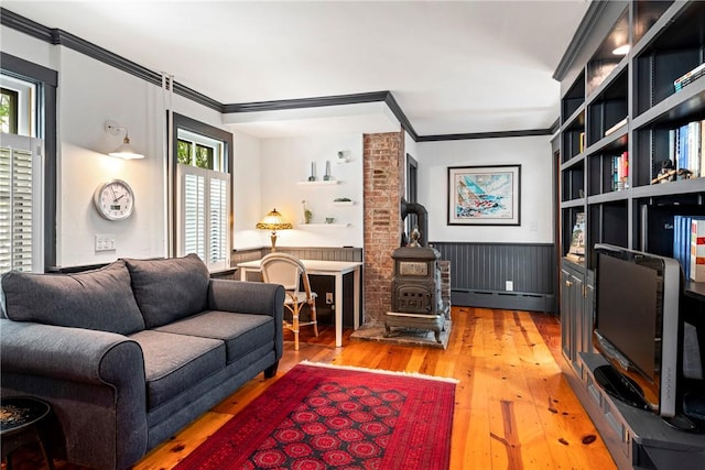 47 Second St, Newport, RI 02840 - living area featuring a wood stove, crown molding, a baseboard radiator, wainscoting, and light wood finished floors