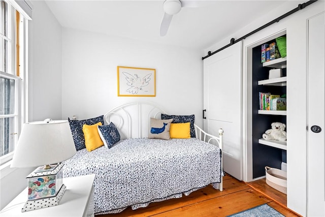 47 Second St, Newport, RI 02840 - bedroom with a barn door, wood finished floors, and ceiling fan