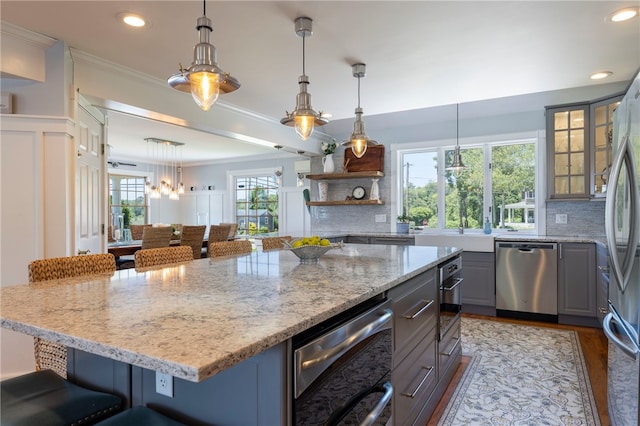 170 W Beach Rd, Charlestown, RI 02813 - kitchen featuring appliances with stainless steel finishes, gray cabinetry, backsplash, a kitchen bar, and ornamental molding