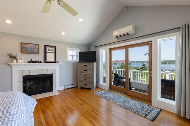 170 W Beach Rd, Charlestown, RI 02813 - living area with an AC wall unit, vaulted ceiling, a baseboard heating unit, wood finished floors, and a ceiling fan