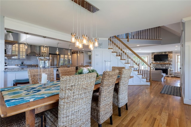 170 W Beach Rd, Charlestown, RI 02813 - dining area with light wood finished floors, stairway, a fireplace, and crown molding