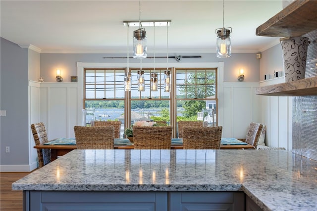 170 W Beach Rd, Charlestown, RI 02813 - kitchen with ornamental molding, a decorative wall, wood finished floors, light stone countertops, and a wainscoted wall