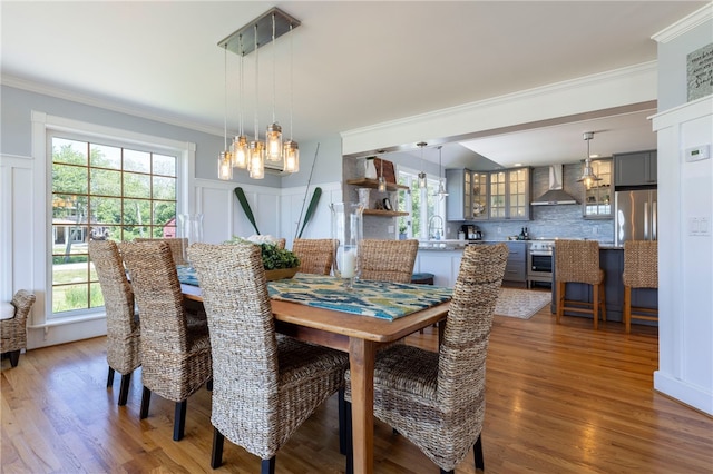 170 W Beach Rd, Charlestown, RI 02813 - dining area with ornamental molding, a decorative wall, wood finished floors, plenty of natural light, and a chandelier