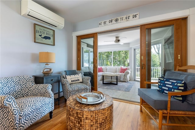 170 W Beach Rd, Charlestown, RI 02813 - living room with a wall mounted air conditioner, a baseboard heating unit, a ceiling fan, and light wood-style floors