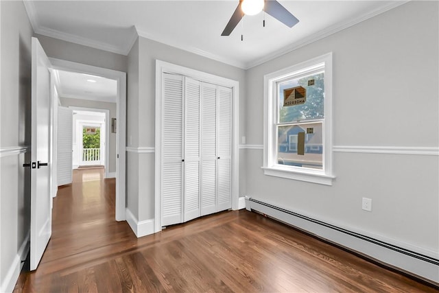 201 Bellman Ave, Warwick, RI 02889 - unfurnished bedroom with a baseboard heating unit, dark wood-style floors, a closet, crown molding, and ceiling fan