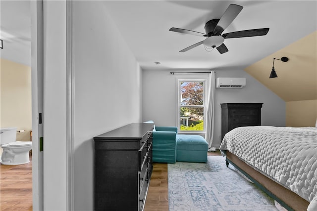 93 E Main Rd, Portsmouth, RI 02871 - bedroom featuring a wall unit AC, wood finished floors, lofted ceiling, ceiling fan, and ensuite bath