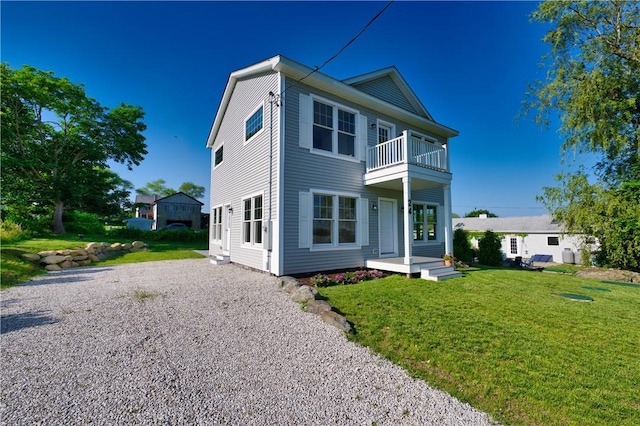 24 Seaspray Way, Little Compton, RI 02837 - back of house with a balcony, a lawn, and gravel driveway