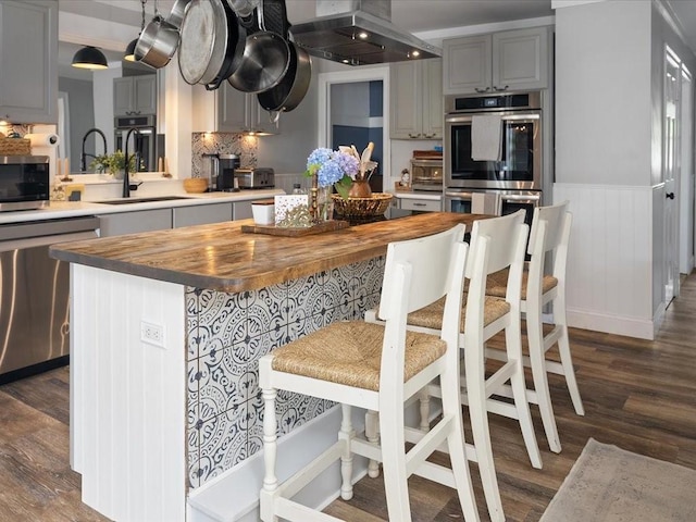 96 Ashaway Rd, Westerly, RI 02891 - kitchen with stainless steel appliances, butcher block countertops, wall chimney exhaust hood, dark wood-style floors, and wainscoting