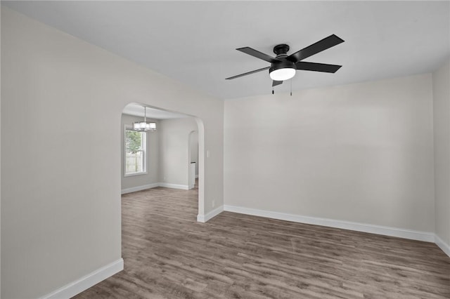 358 Pawtuxet Ave, Warwick, RI 02888 - unfurnished room with arched walkways, wood finished floors, ceiling fan, and a chandelier