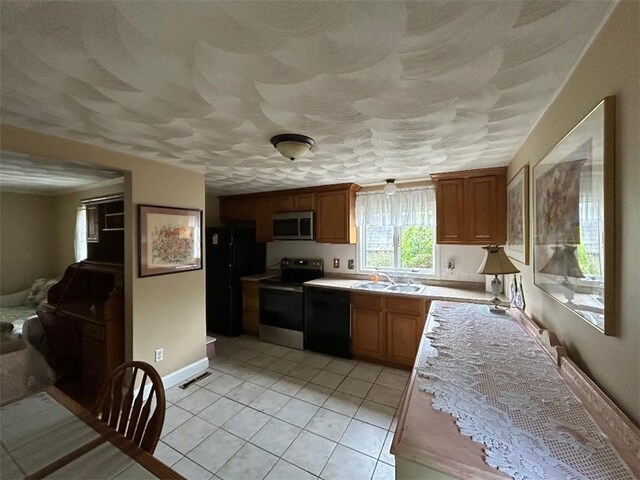163 Reynolds Ave, Warwick, RI 02889 - kitchen featuring black appliances, light countertops, light tile patterned floors, and brown cabinets