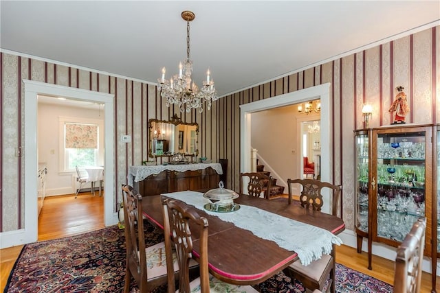 65 Lyndhurst Ave, Providence, RI 02908 - dining area featuring a chandelier, wallpapered walls, wood finished floors, stairway, and ornamental molding