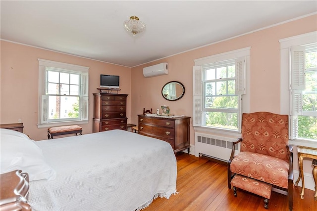 65 Lyndhurst Ave, Providence, RI 02908 - bedroom featuring radiator heating unit, a wall mounted air conditioner, light wood-style floors, and crown molding
