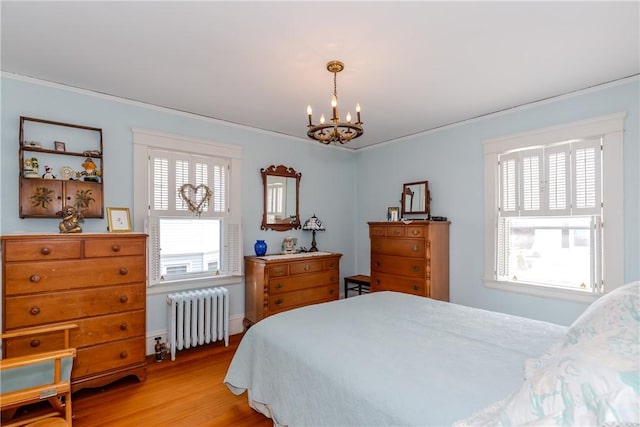 65 Lyndhurst Ave, Providence, RI 02908 - bedroom featuring radiator, a chandelier, multiple windows, light wood-style floors, and crown molding