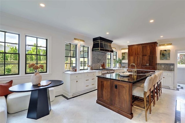 290 Blackstone Blvd, Providence, RI 02906 - kitchen featuring backsplash, recessed lighting, custom range hood, a breakfast bar, and a center island with sink