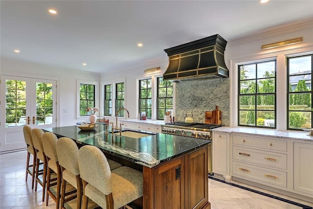 290 Blackstone Blvd, Providence, RI 02906 - kitchen with custom exhaust hood, recessed lighting, dark stone counters, tasteful backsplash, and a center island with sink